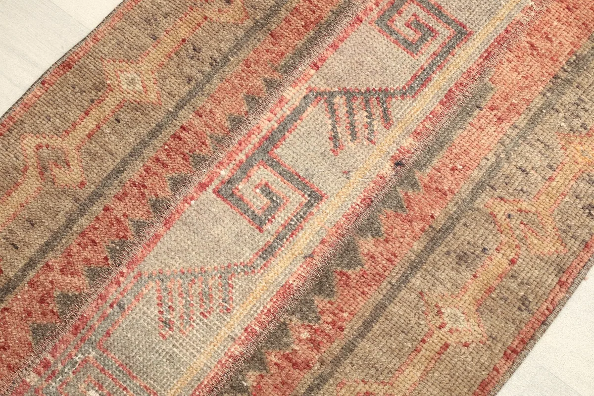 Angled view showcasing the texture and the tribal motifs within the rust and beige color bands.