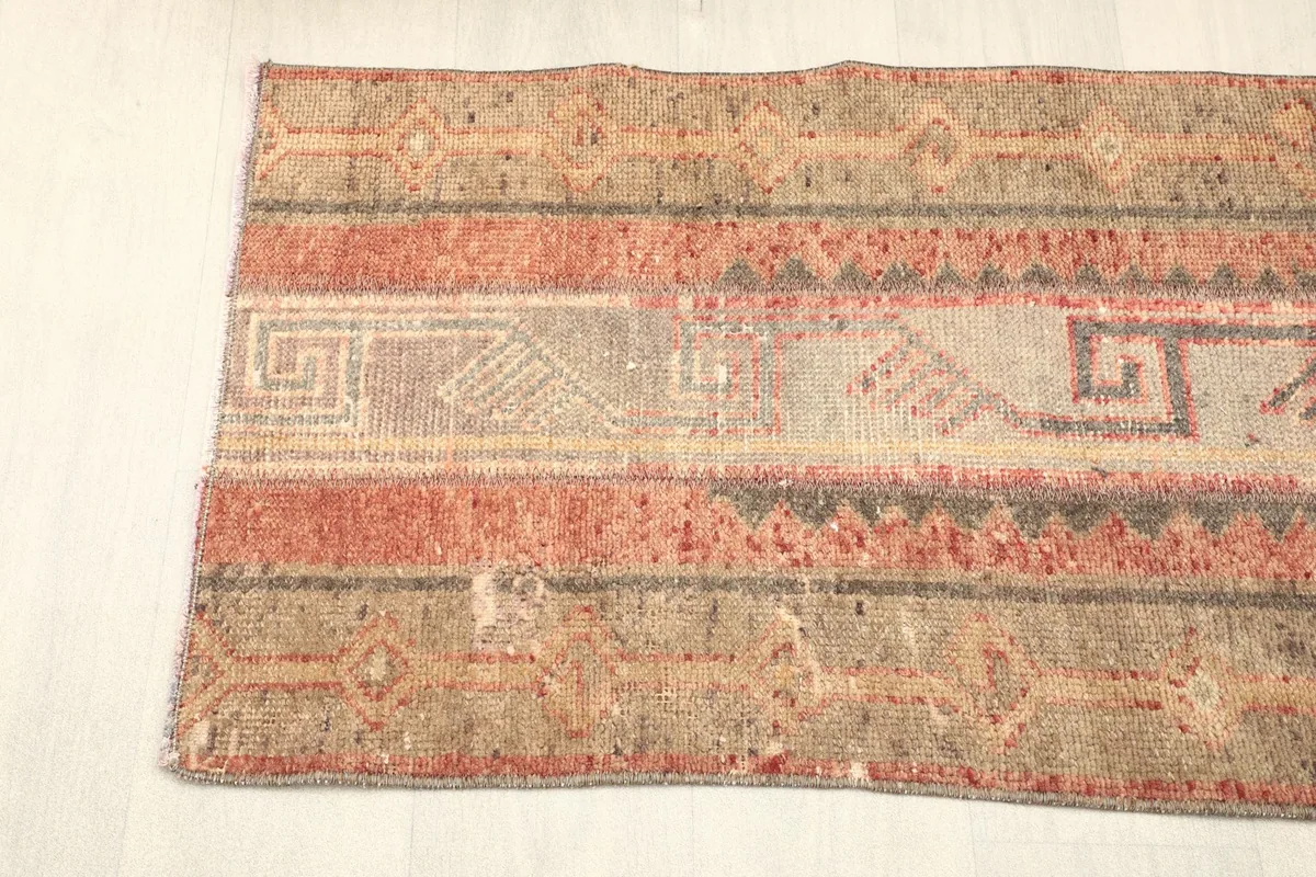 Angled view of the opposite end of the rug, displaying the consistent color scheme and unique patterns.