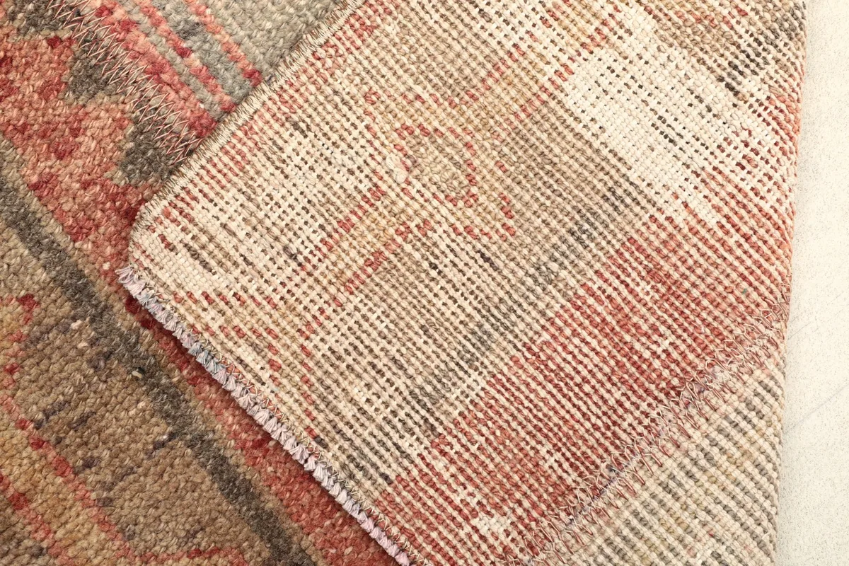 View of the rug's reverse side, revealing the hand-knotted cotton foundation and wool pile construction.