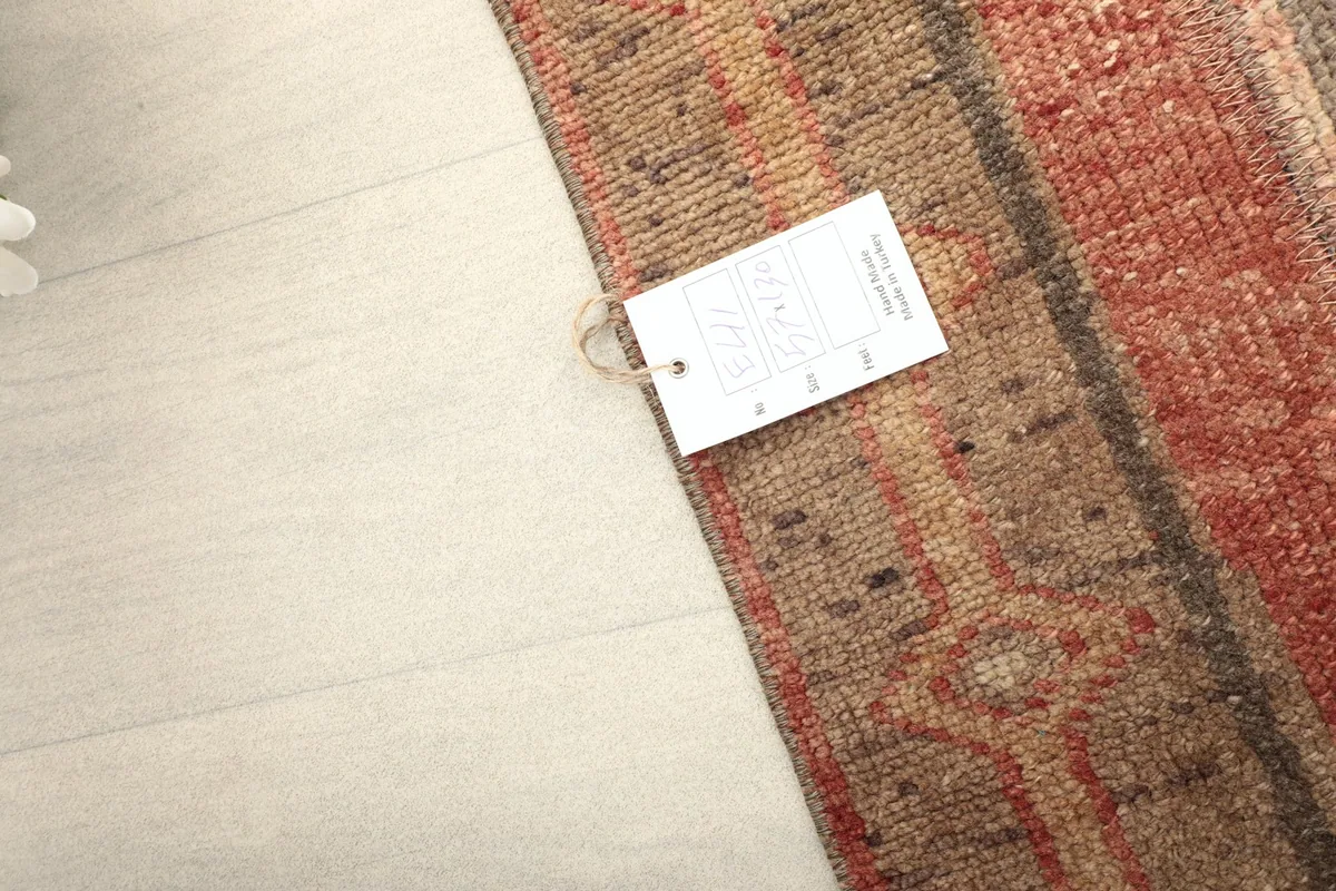 Corner of the rug with the brand tag, showing the edge finish and pile texture.