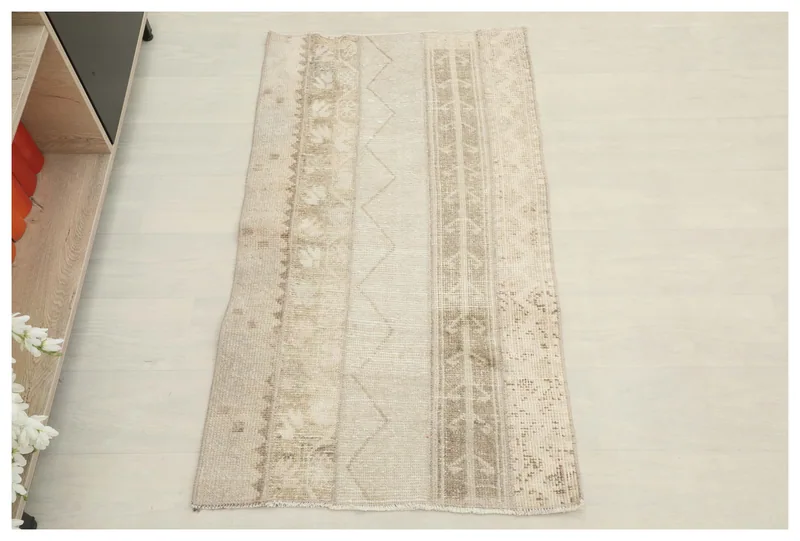 Full overhead view of the ivory and beige vintage Anatolian rug on a white floor.