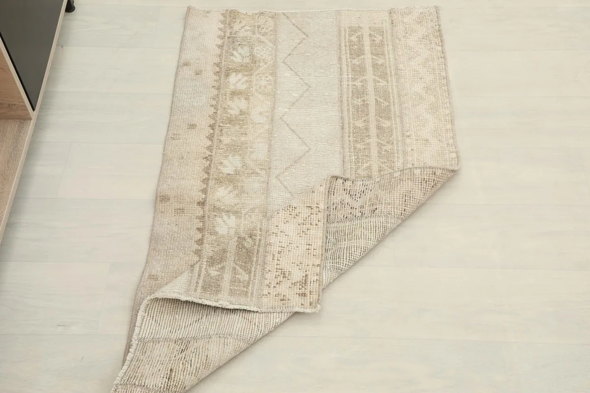 The rug partially folded to show both the pile and the back, emphasizing its flexibility.