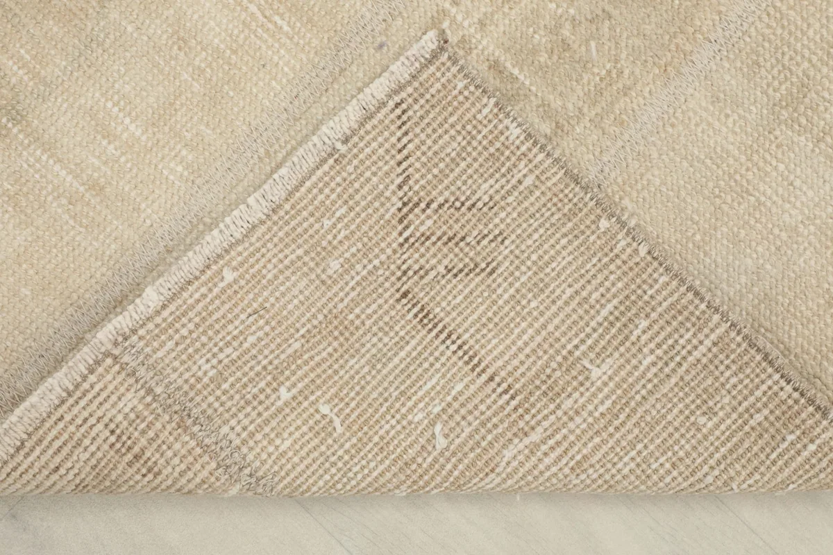 View of the back of the rug, revealing the cotton foundation and knotting structure.