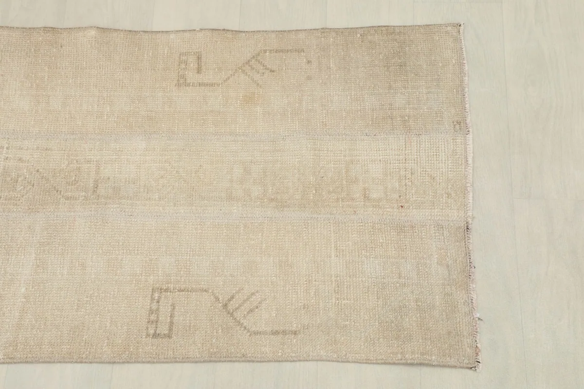Overhead view focusing on the upper half of the rug, showing the faded design.