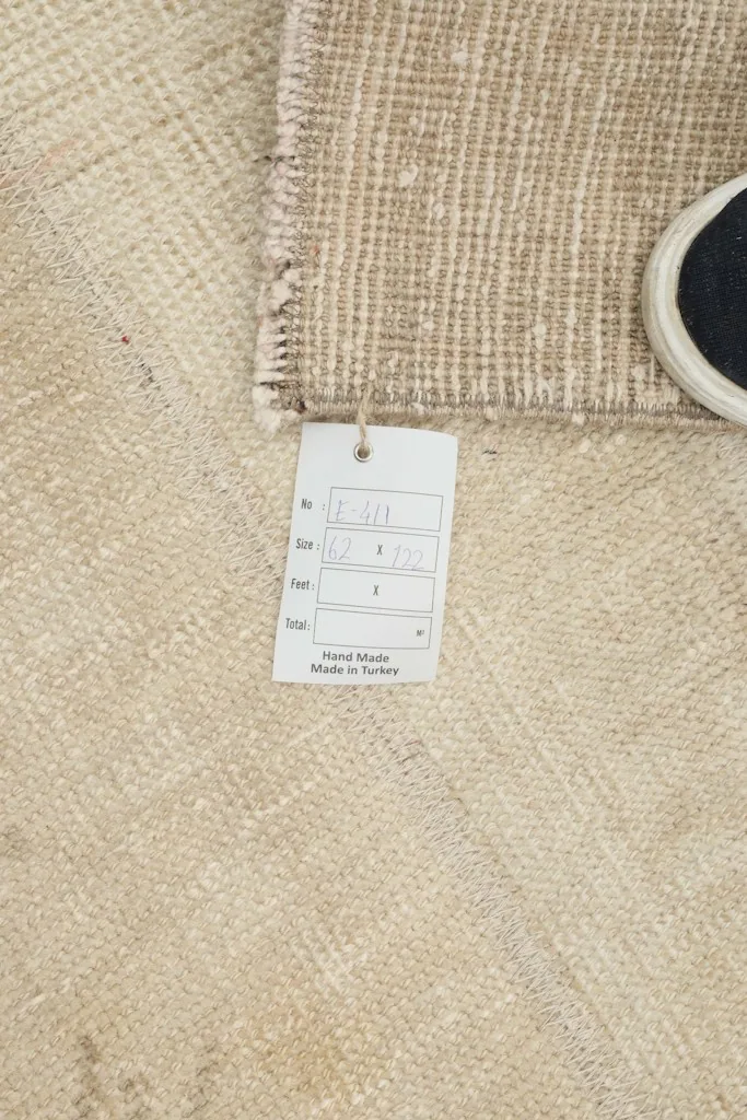 Close-up of the rug's corner with the product tag, confirming its hand-made origin in Turkey.