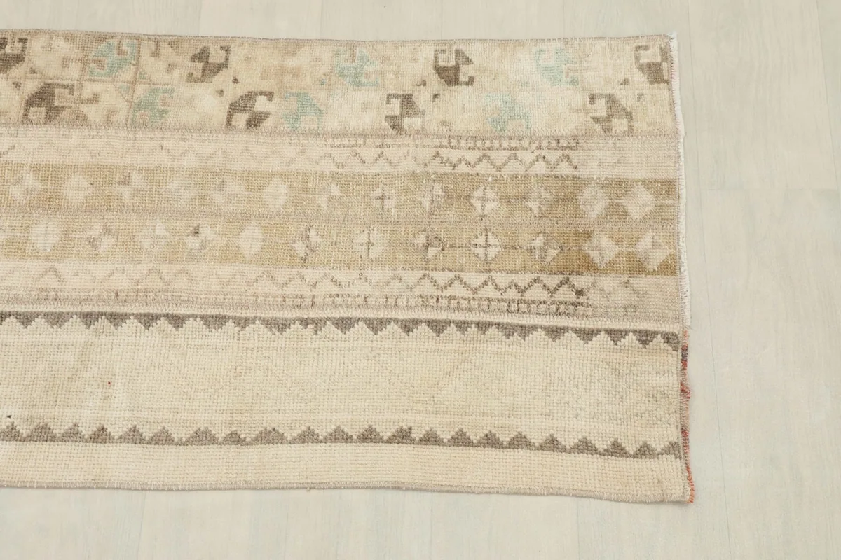 Detail view of the left side of the beige rug, highlighting geometric patterns