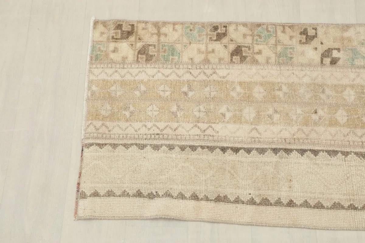 Detail view of the right side of the beige rug, showing striped design elements