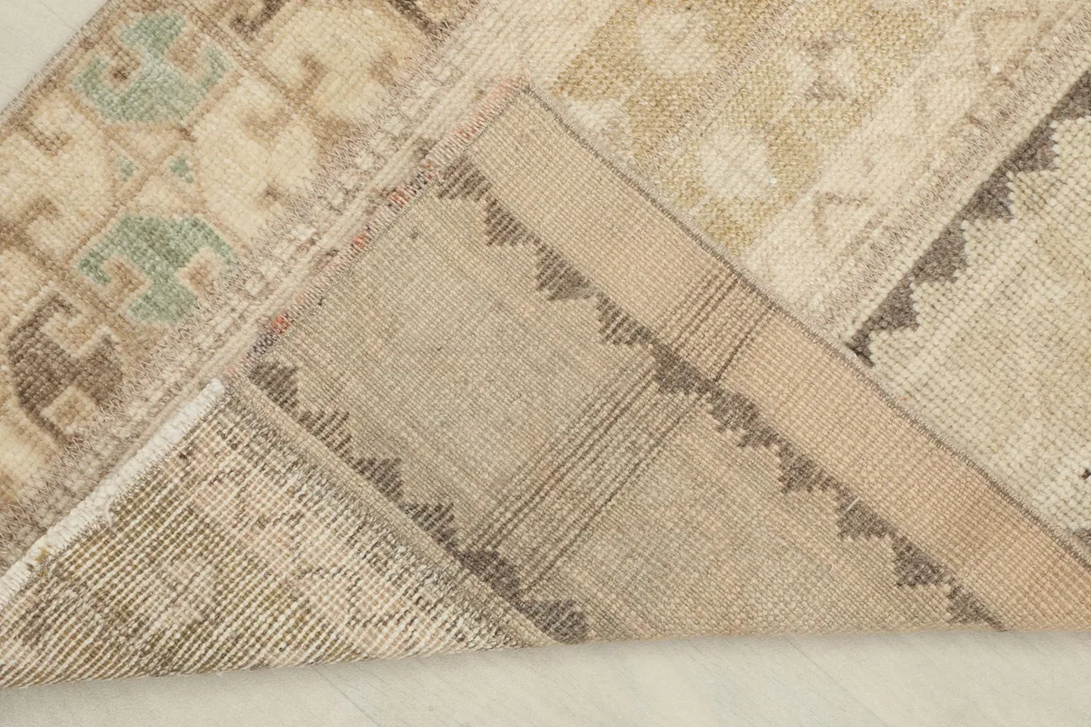 View of the back of the hand-knotted wool rug, showing cotton foundation