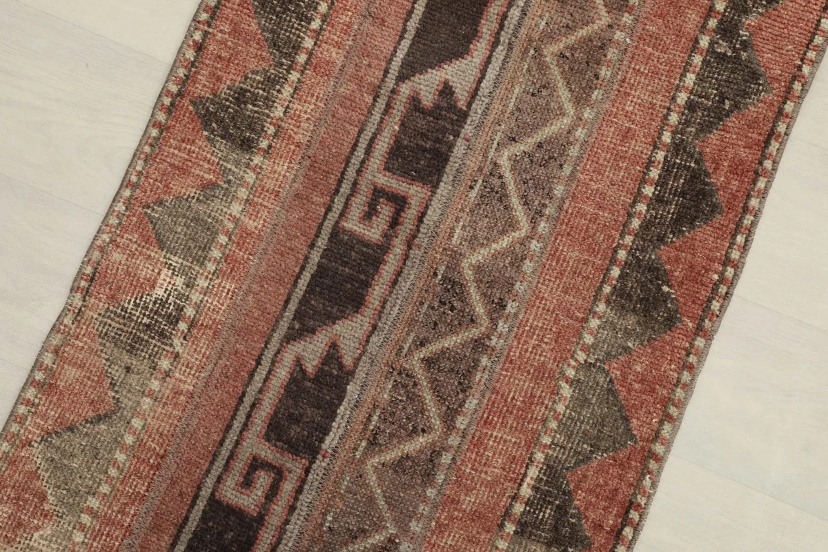 Diagonal view across the rug's surface, showcasing the varied geometric stripes.