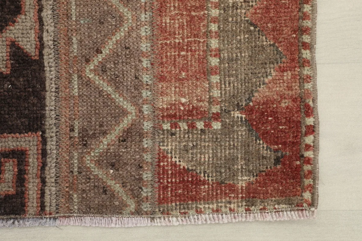 Detailed view of the rug's edge, showing the low pile and color variations.