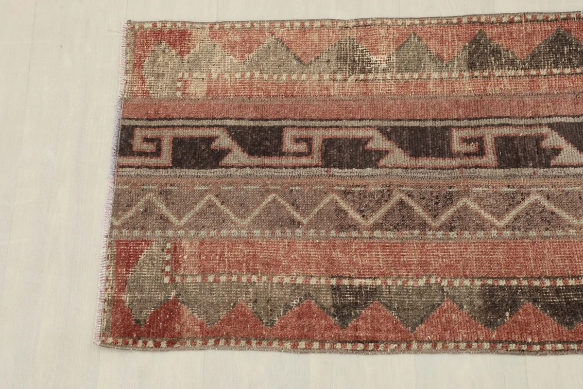 Overhead view showing the bottom section of the rug's tribal geometric design and colors.