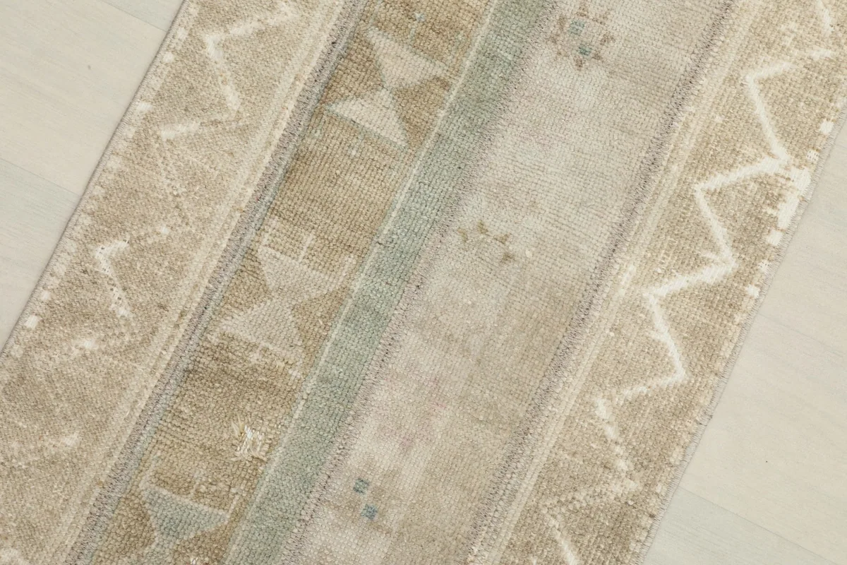 Close-up showing the varied tan, beige, and blue tones and low pile texture
