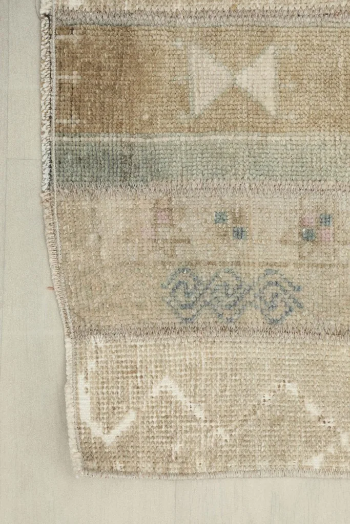 Edge detail of the rug, showing the hand-knotted structure and short fringes