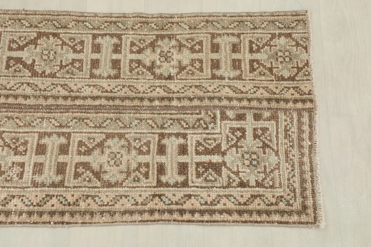Close-up view of one end of the rug, highlighting the intricate geometric patterns and border design.