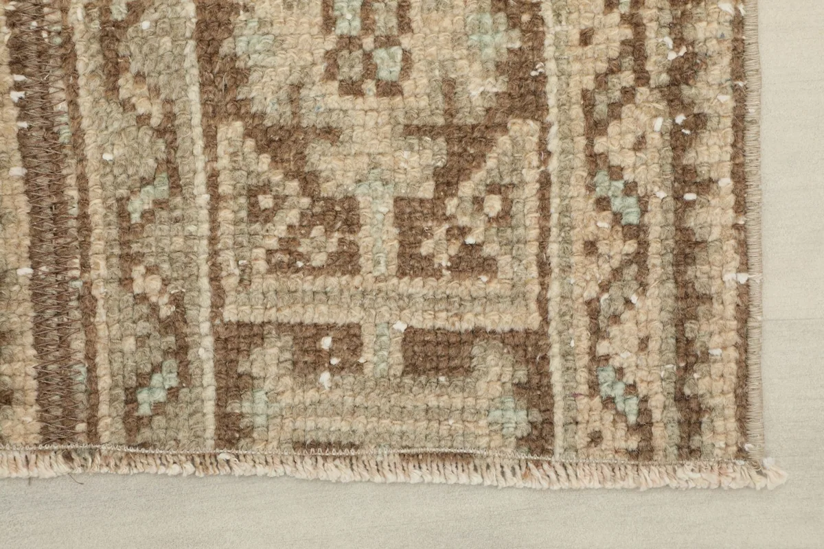 Close-up of the short, natural fringe and the finished edge of the vintage Anatolian rug.