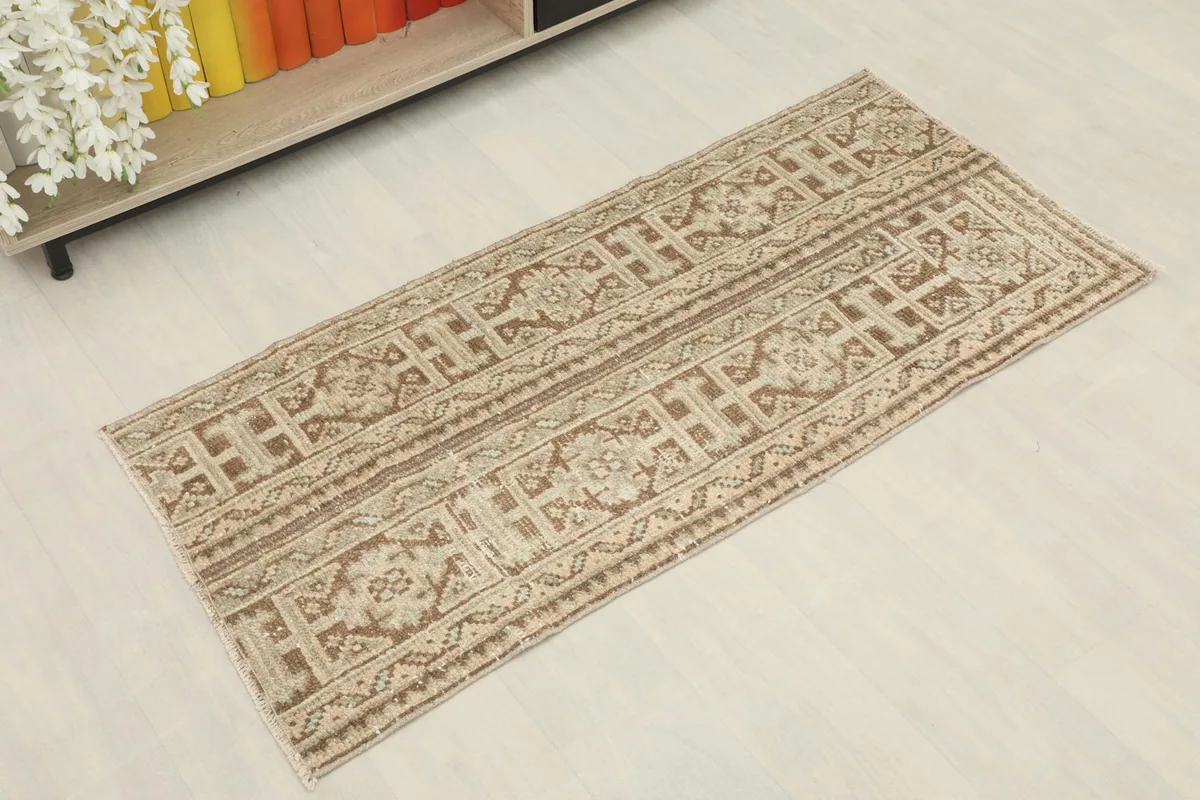 Overhead view of the vintage rug, showing its full length and geometric patterns from a slight angle.