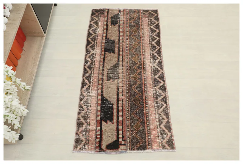 Full top view of the brown, beige, and rose geometric striped vintage Anatolian rug on a white background