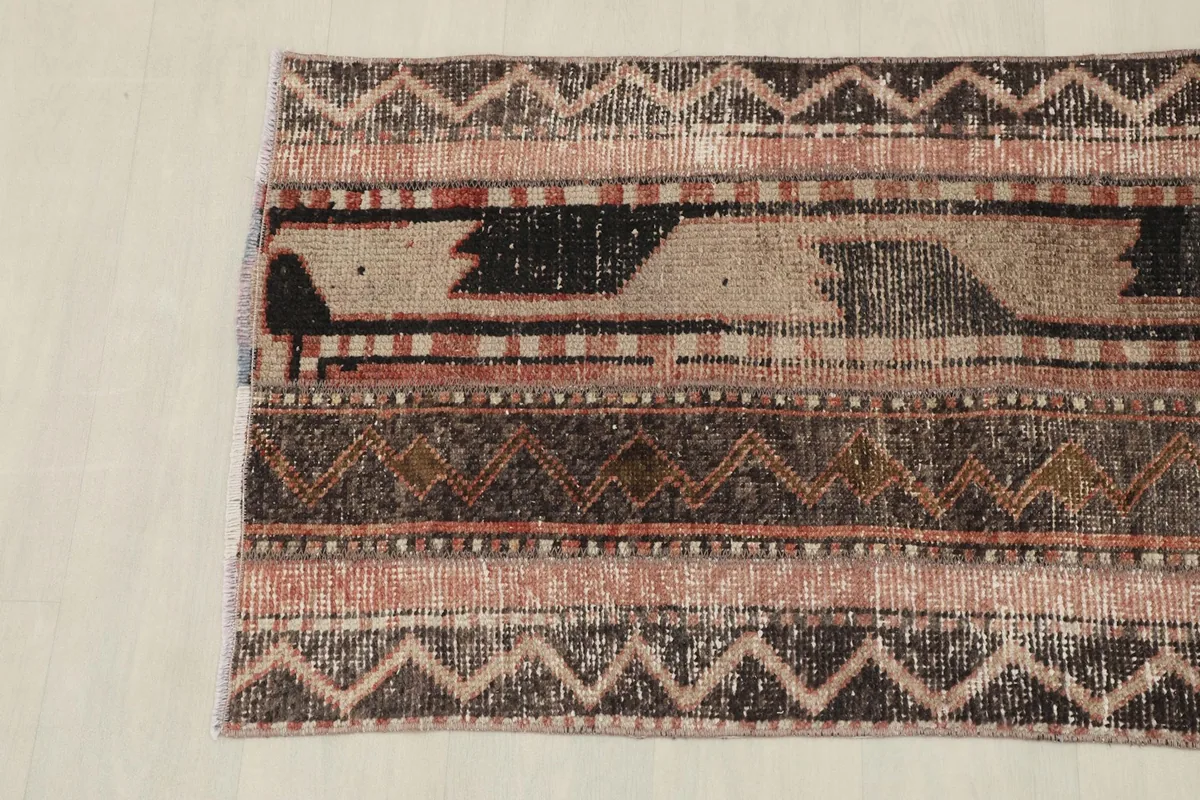Detail view of the rug's other end, showcasing the varied geometric designs and color transitions