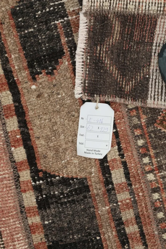 Close-up view of a corner of the rug with the product tag, showing 'Hand Made in Turkey' details