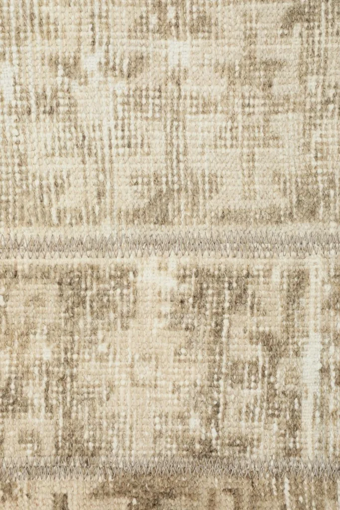 Close-up of the low wool pile, revealing the hand-knotted texture and color variation.