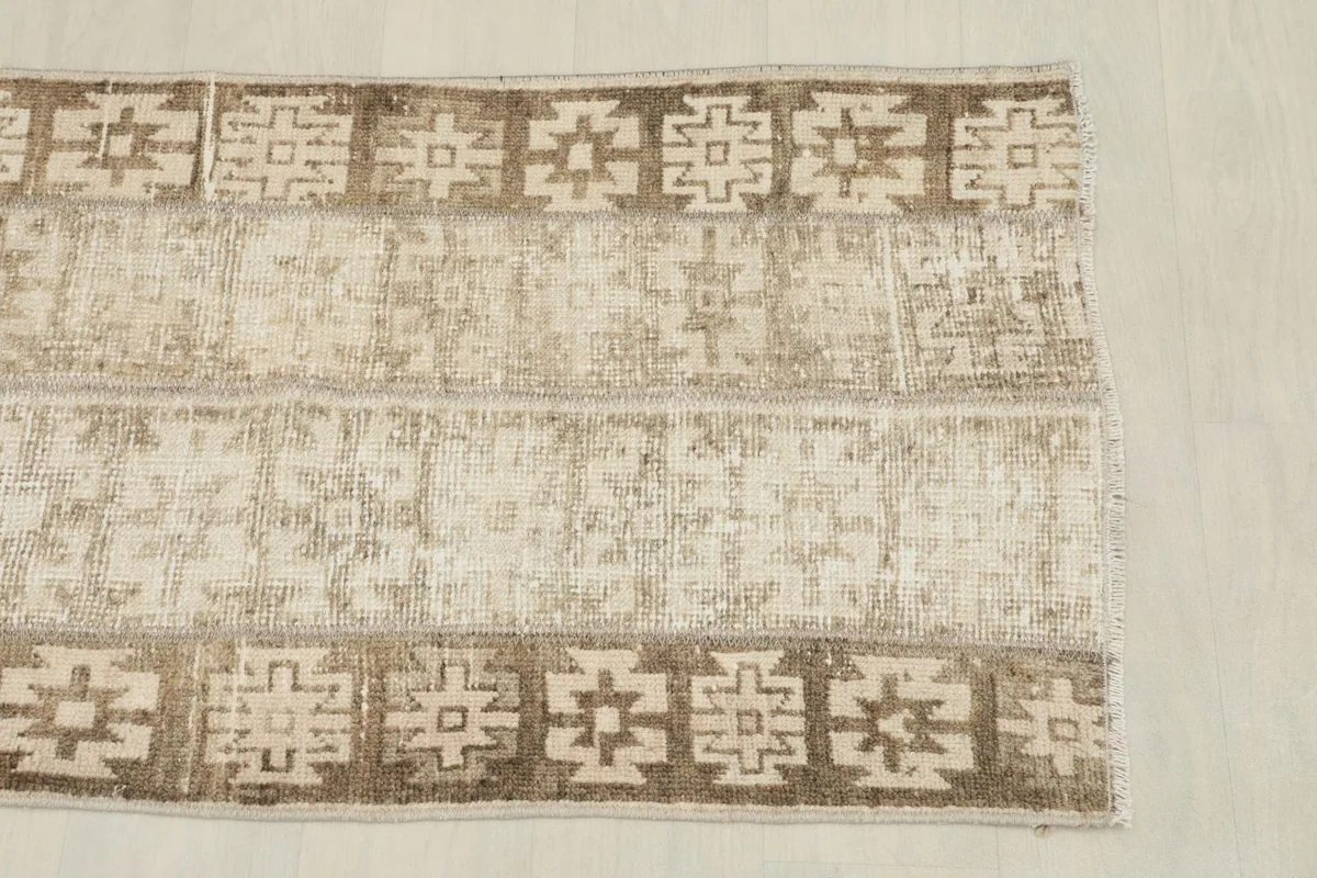 Overhead shot of one end of the rug, highlighting the worn textures and tribal patterns.