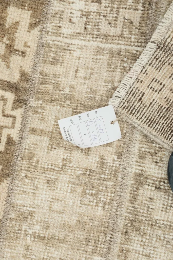 Close-up of the rug with a size tag, showing the pile and fringe details.