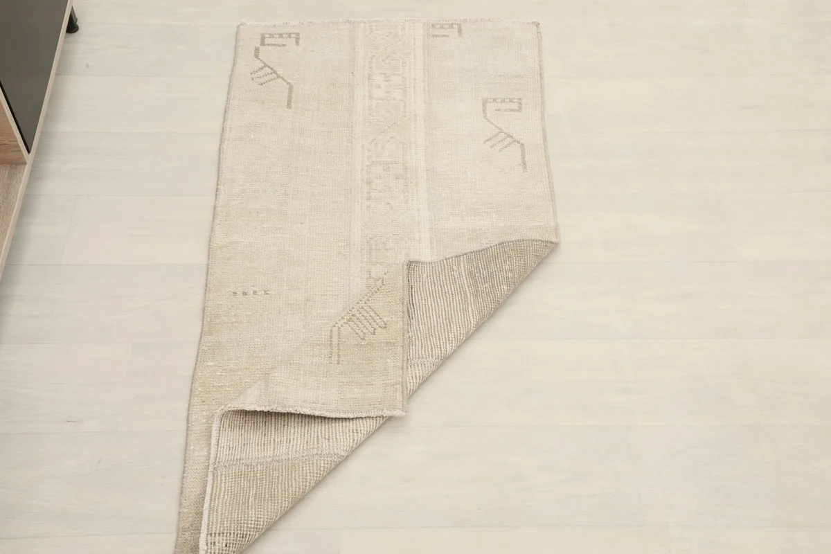 Rug partially folded, demonstrating its flexibility and the thickness of the wool pile