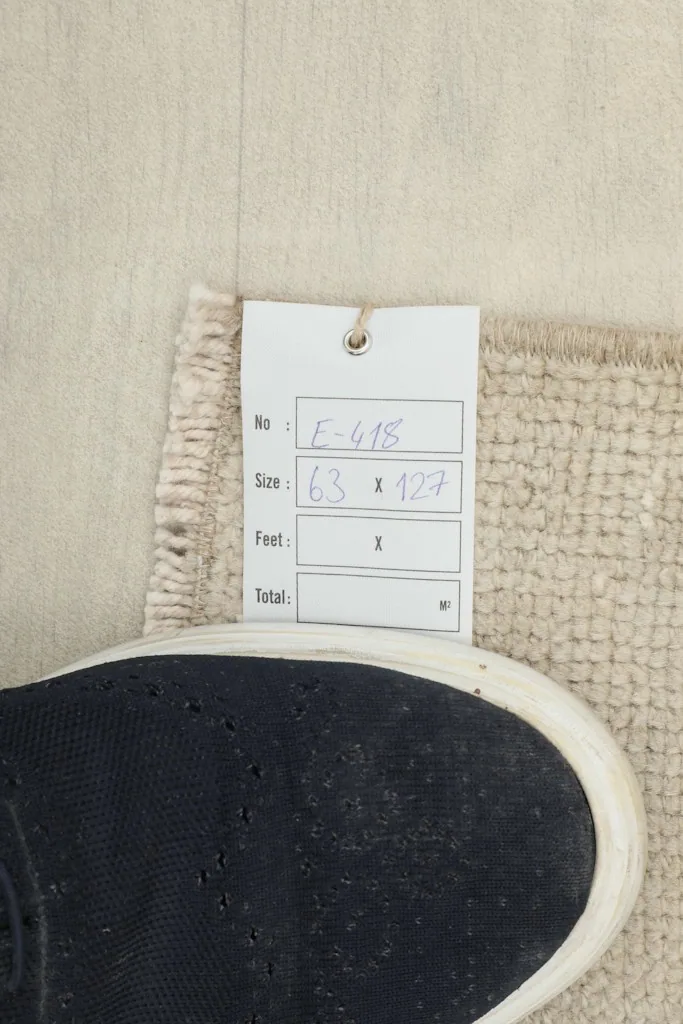 Close-up of the rug's label with size information next to a foot for scale