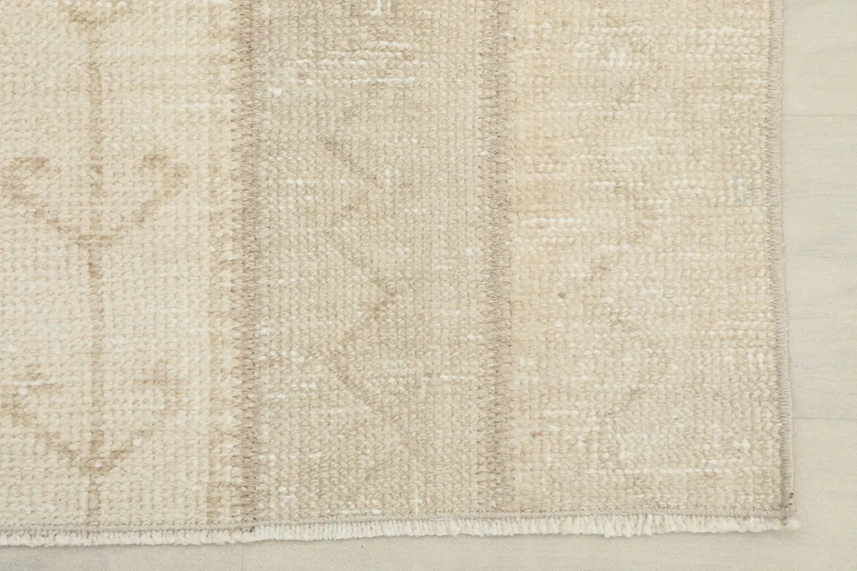 Corner detail of the rug, showing the edge finish and the low pile.