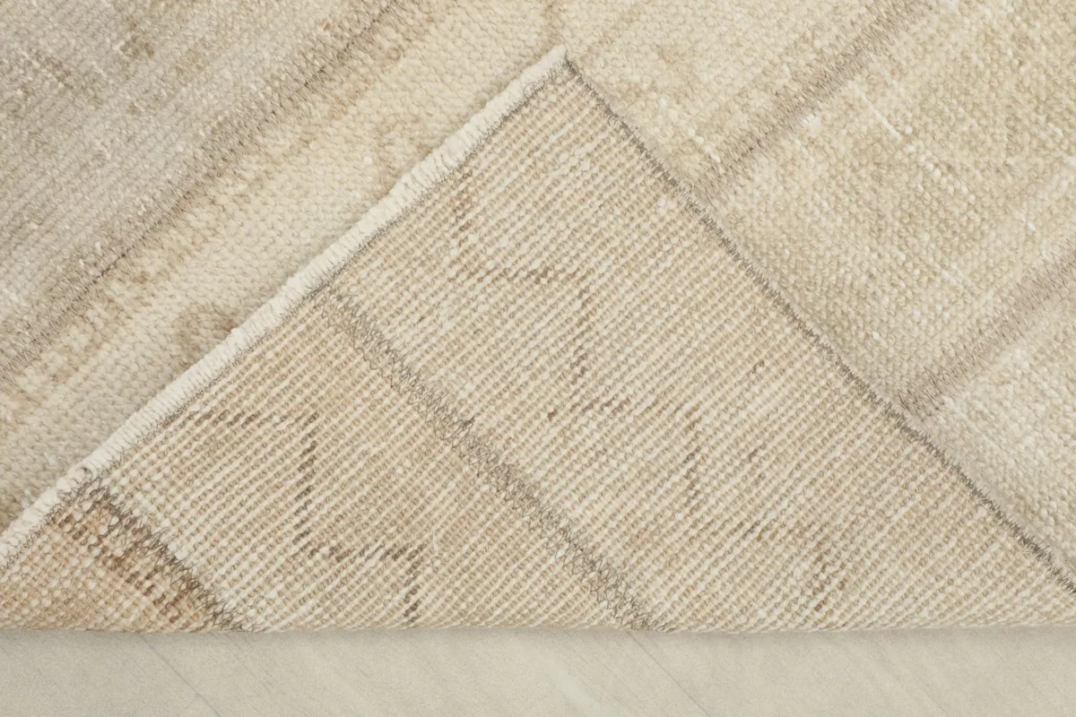 View of the back of the rug, revealing the cotton foundation and knotting structure.