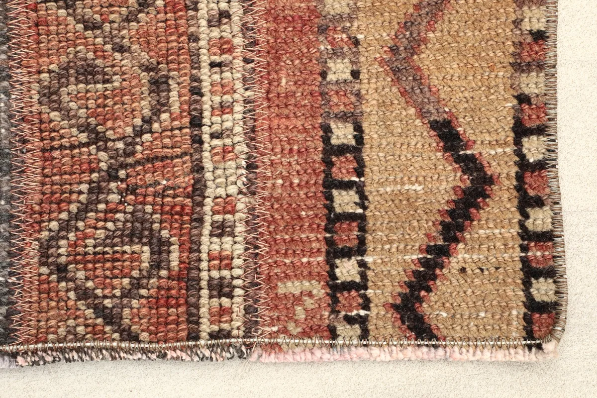 Close-up detail of the rug's edge, highlighting the hand-knotted wool pile and cotton foundation
