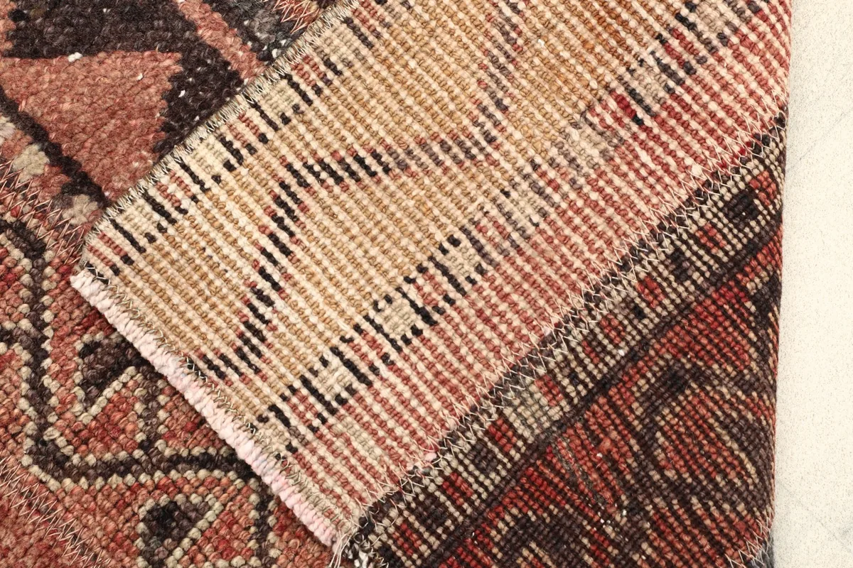 View of the back of the rug where it is folded, revealing the tight hand-knotted construction