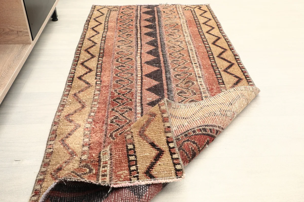 The rug partially folded over, showing the thickness of the wool pile and the overall design