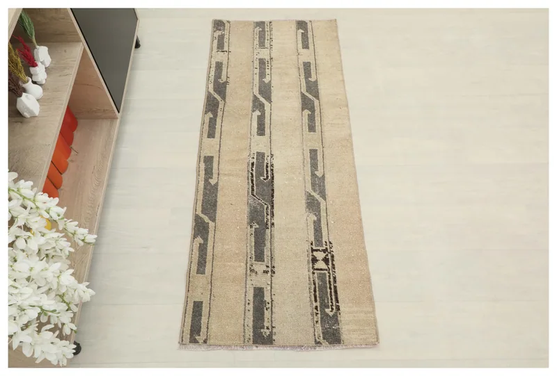 Full top view of the beige and gray abstract vintage runner rug on a white background.