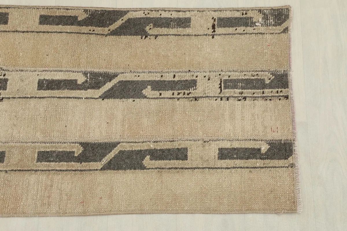 Detailed view of the end of the runner rug, highlighting the geometric motifs and texture.