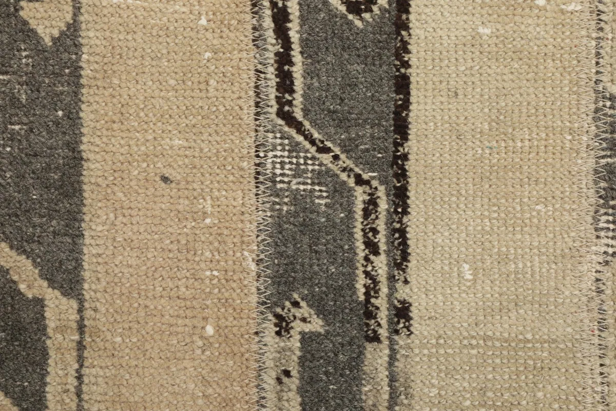 Macro view of the low wool pile and the hand-knotted texture of the vintage rug.