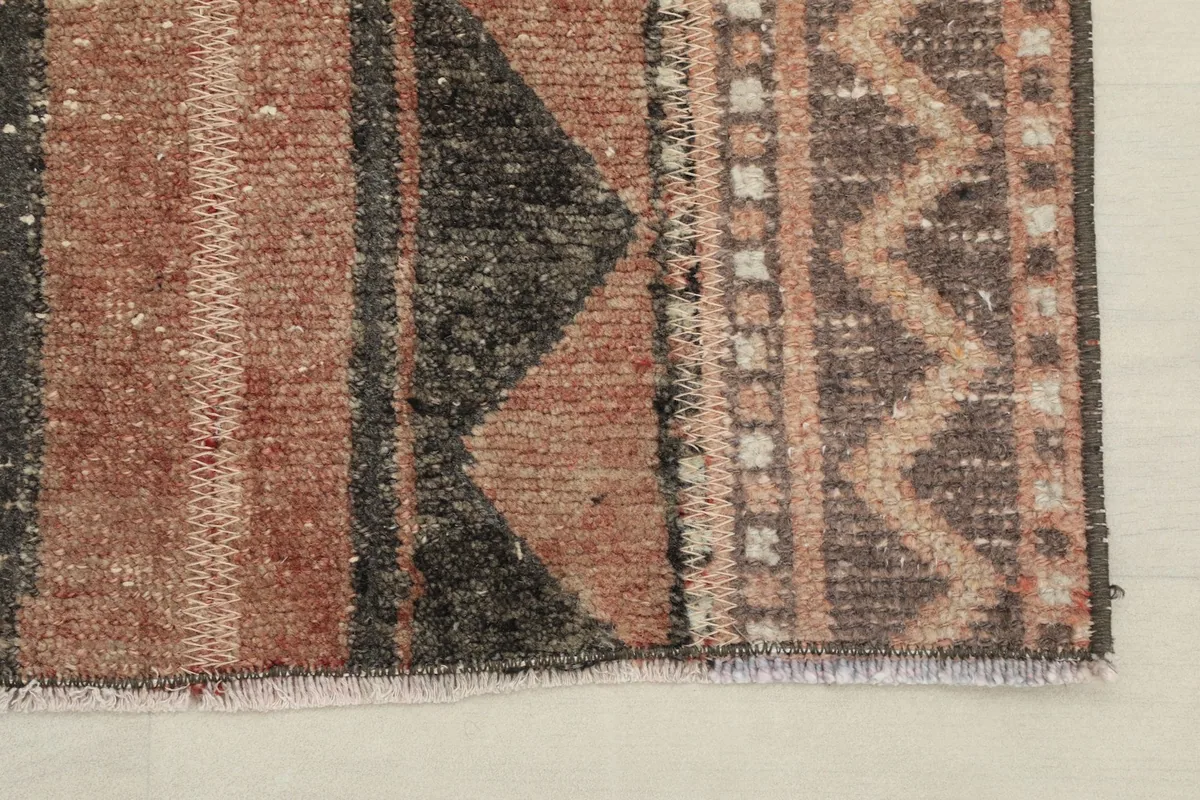 Detail of the short fringe and the edge finishing of the vintage hand-knotted rug.