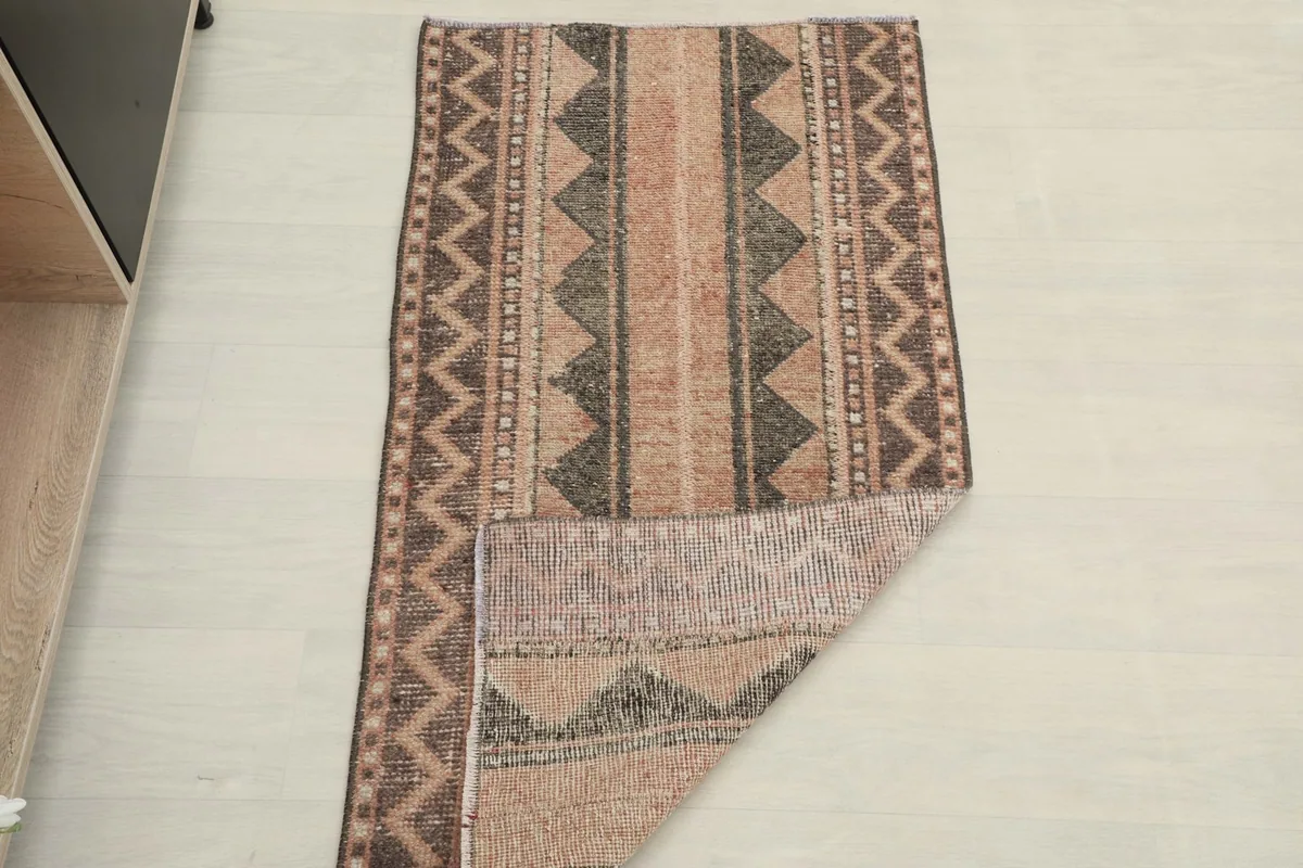 Rug partially folded, showing the flexibility and thickness of the vintage wool area rug.