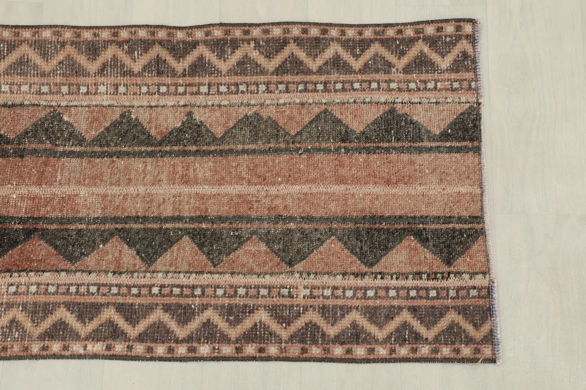 Overhead view of one end of the rug, highlighting the varied geometric patterns and colors.