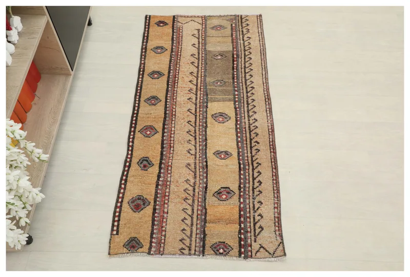 Full top view of the 2'3" x 4'8" vintage Anatolian rug with tan and brown stripes and geometric motifs.