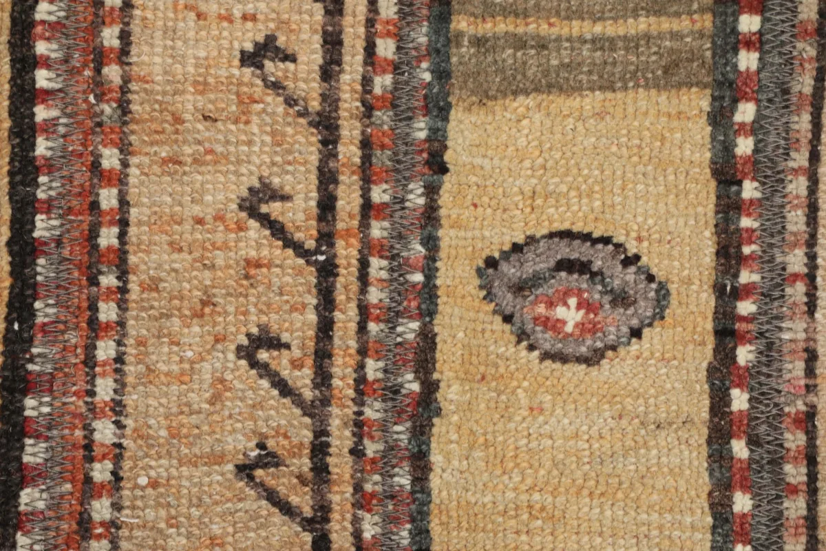 Detailed close-up of the low wool pile, showing the individual knots and the subtle color shifts in the tan and brown