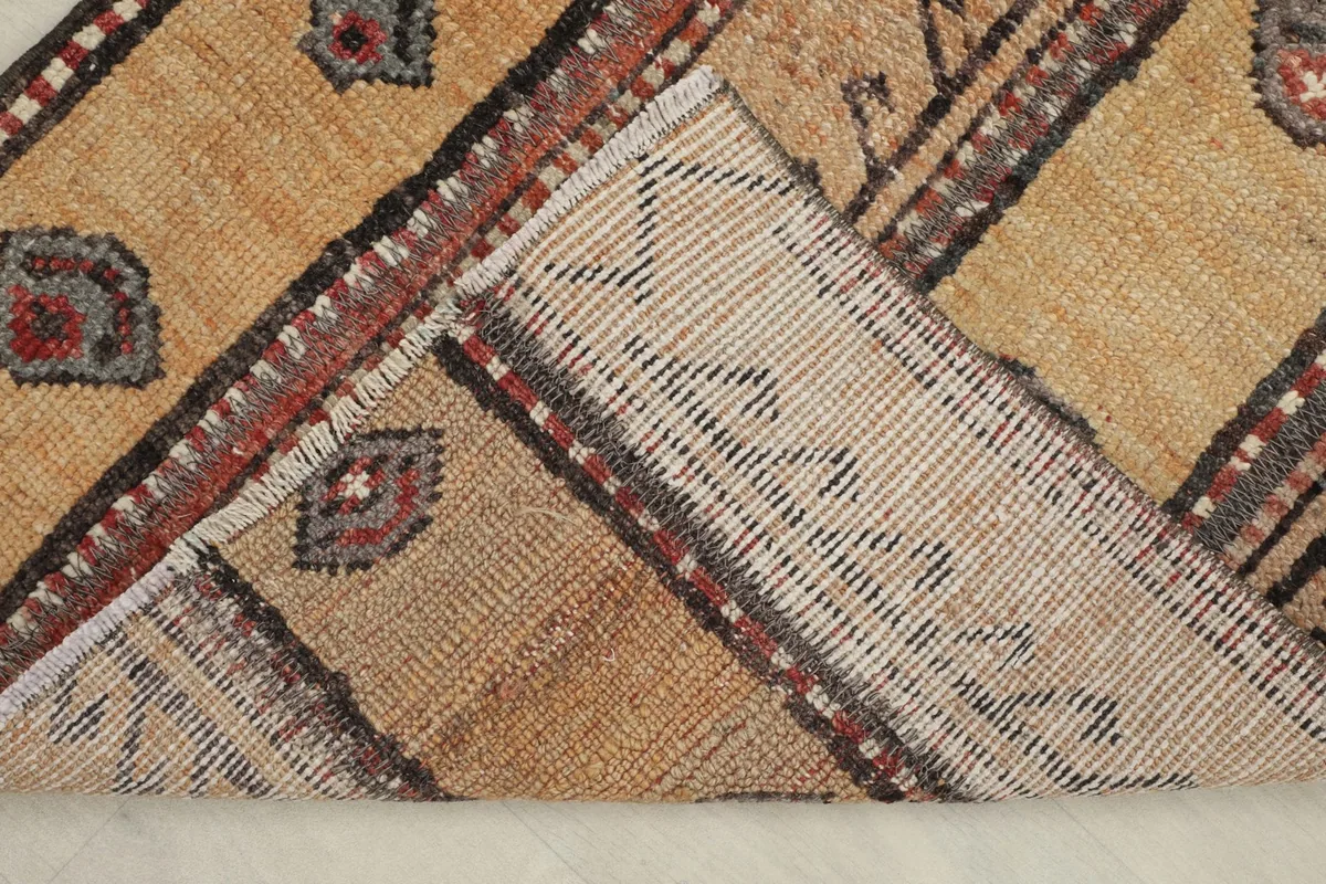Underside of the rug, showing the cotton foundation and the reverse of the hand-knotted wool pile.