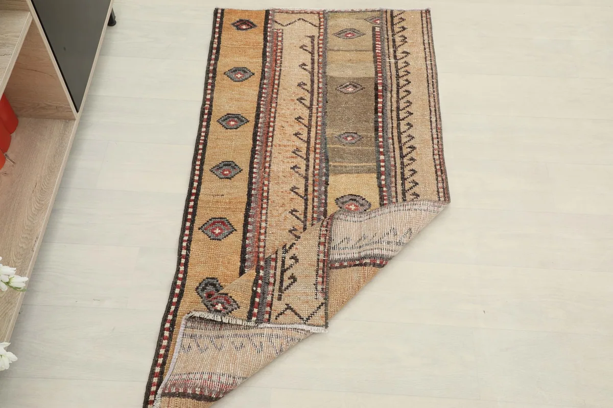 Rug partially folded, demonstrating its flexibility and the natural drape of the vintage wool material.