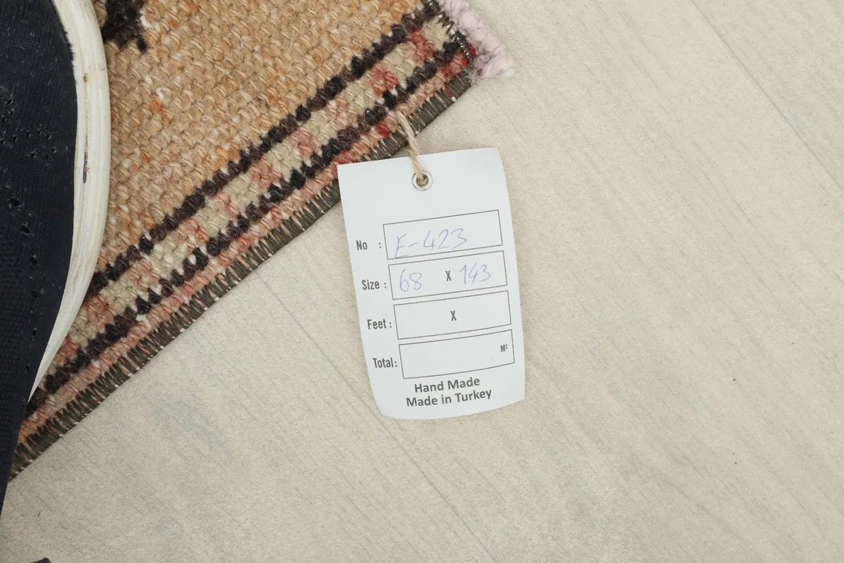 Tag displaying the rug's dimensions (68 x 143 cm) and confirming it is hand-made in Turkey.