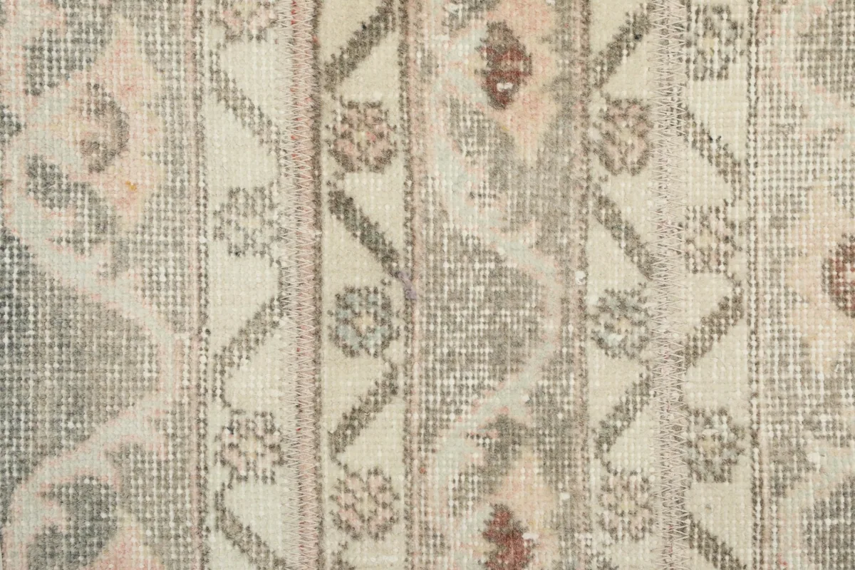 Extreme close-up of the wool pile, showing the hand-knotted texture and muted colors