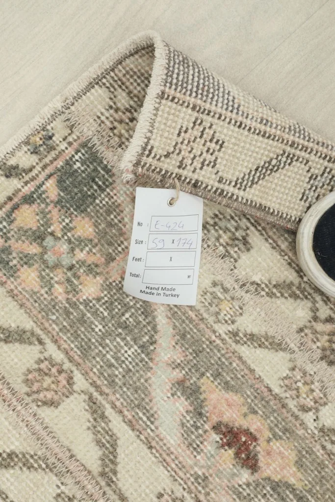 Close-up of the rug with a label showing its dimensions and origin