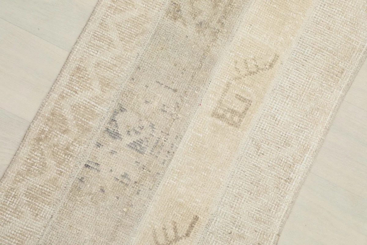 Angled close-up showing the distinct patchwork seams and the varied pile of the vintage rug