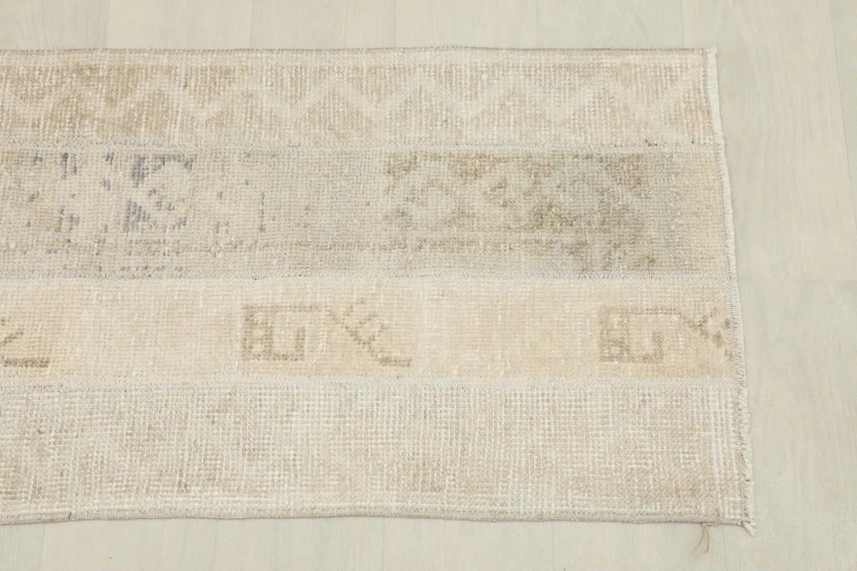 Close-up of the rug's surface, highlighting the different beige and tan patches with subtle patterns