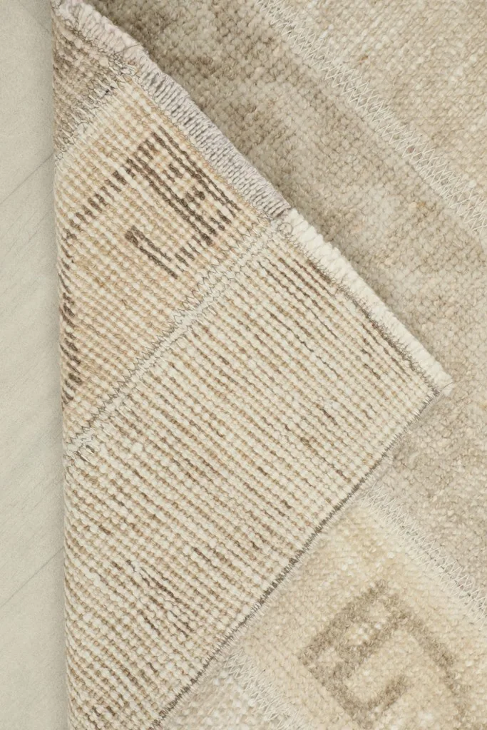 View of the rug's cotton foundation and the reverse side of the hand-knotted wool pile