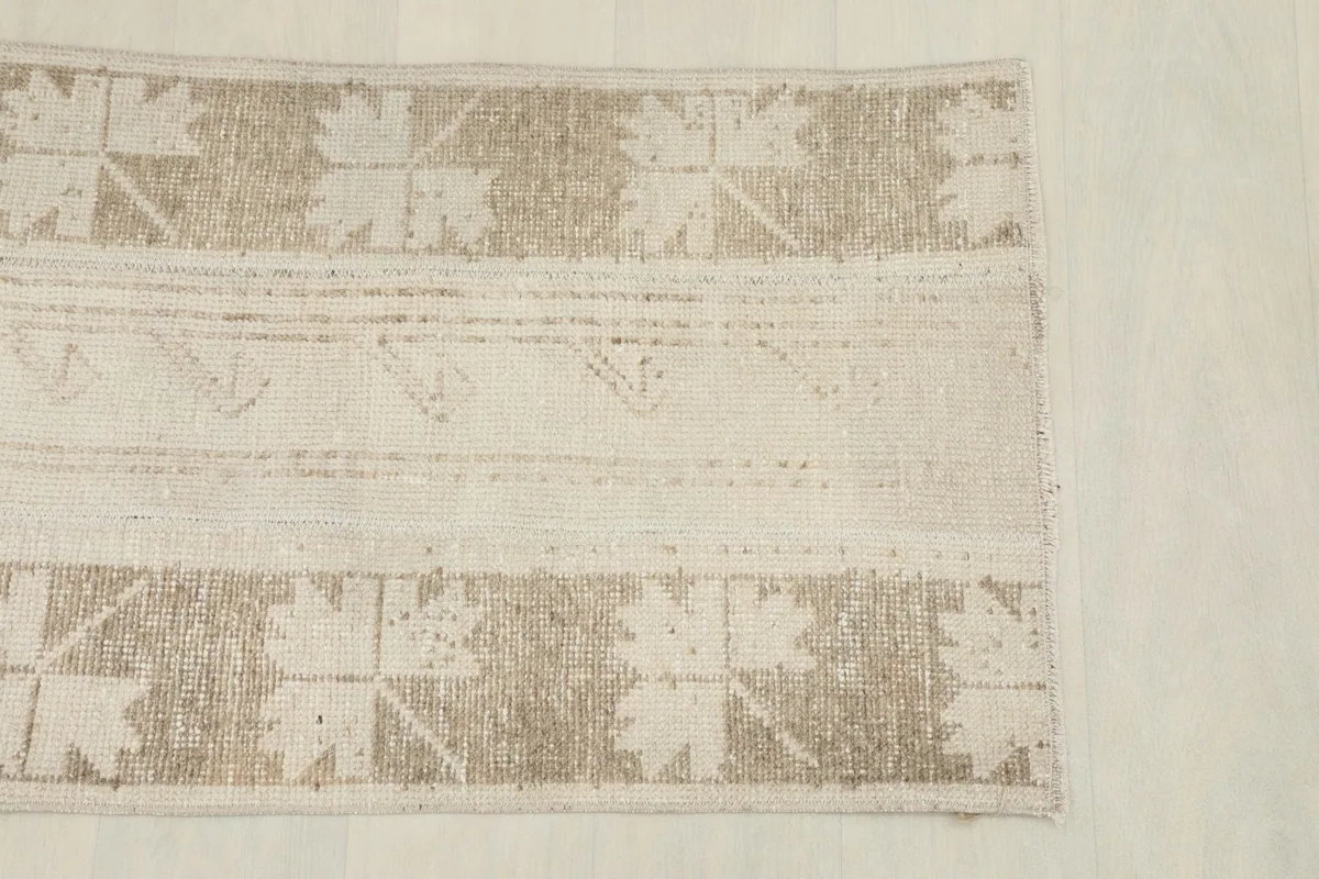 Overhead shot of the rug's top half, showing the tan geometric border design